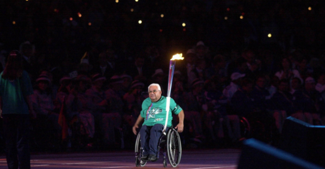 Kevin Coombs carries the Paralympic torch as part of the torch relay at the 2000 Summer Paralympics Opening Ceremony