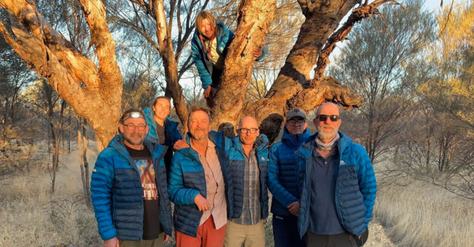 Paul Richard and other participants, hugging in front of a tree