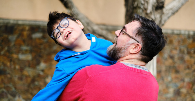 Father holding his son in the garden.