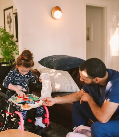 Young girl in a mobility wheelchair with a support worker