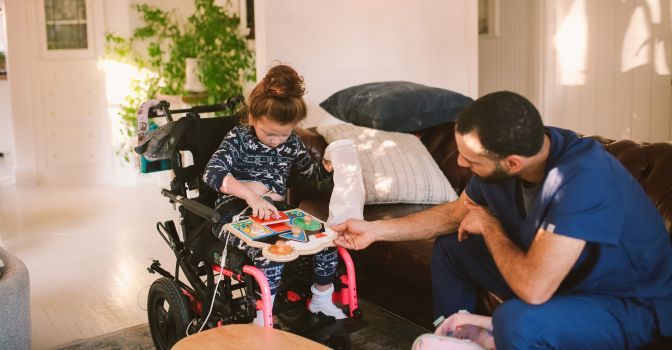 Young girl in a mobility wheelchair with a support worker