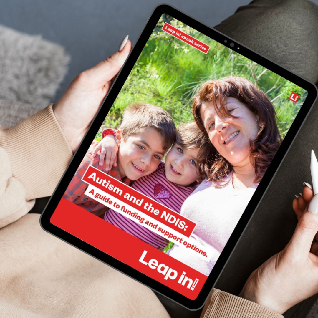 Woman holding a tablet on her lap with the Leap in! Autism ebook showing on the display.