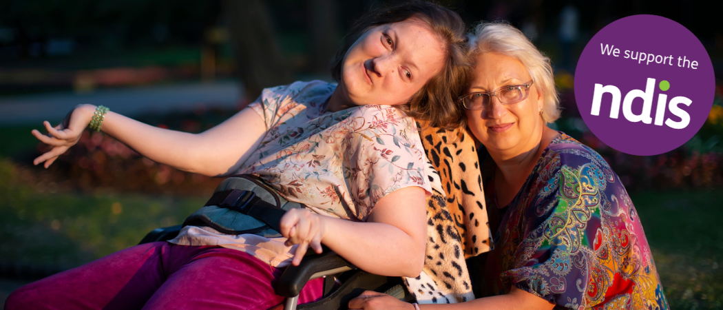 Women in a wheelchair with a lady crouched down behind her